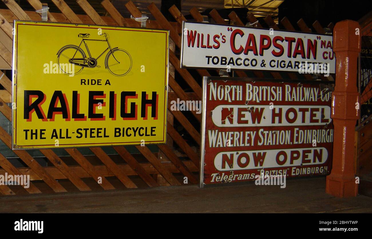 Historische britische Bahnhofwerbung für Raleigh Fahrräder, Wills Tabak und Zigaretten, Capstan Navy Cut und das neue Waverley Hotel, Edinburgh, Schottland Stockfoto