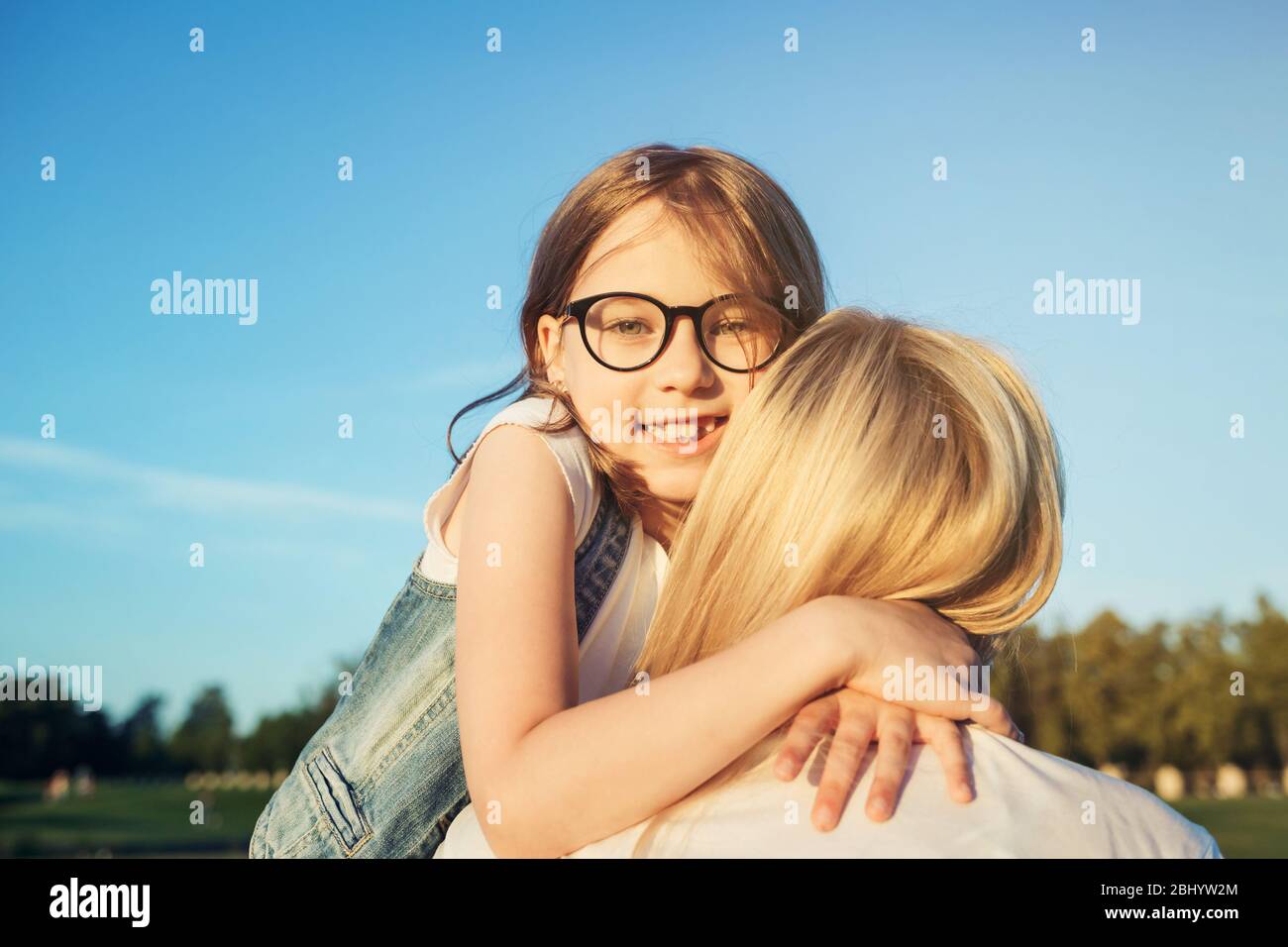 Kleine Tochter umarmt ihre Mutter. Muttertag Konzept. Familie und Mutterschaft. Stockfoto
