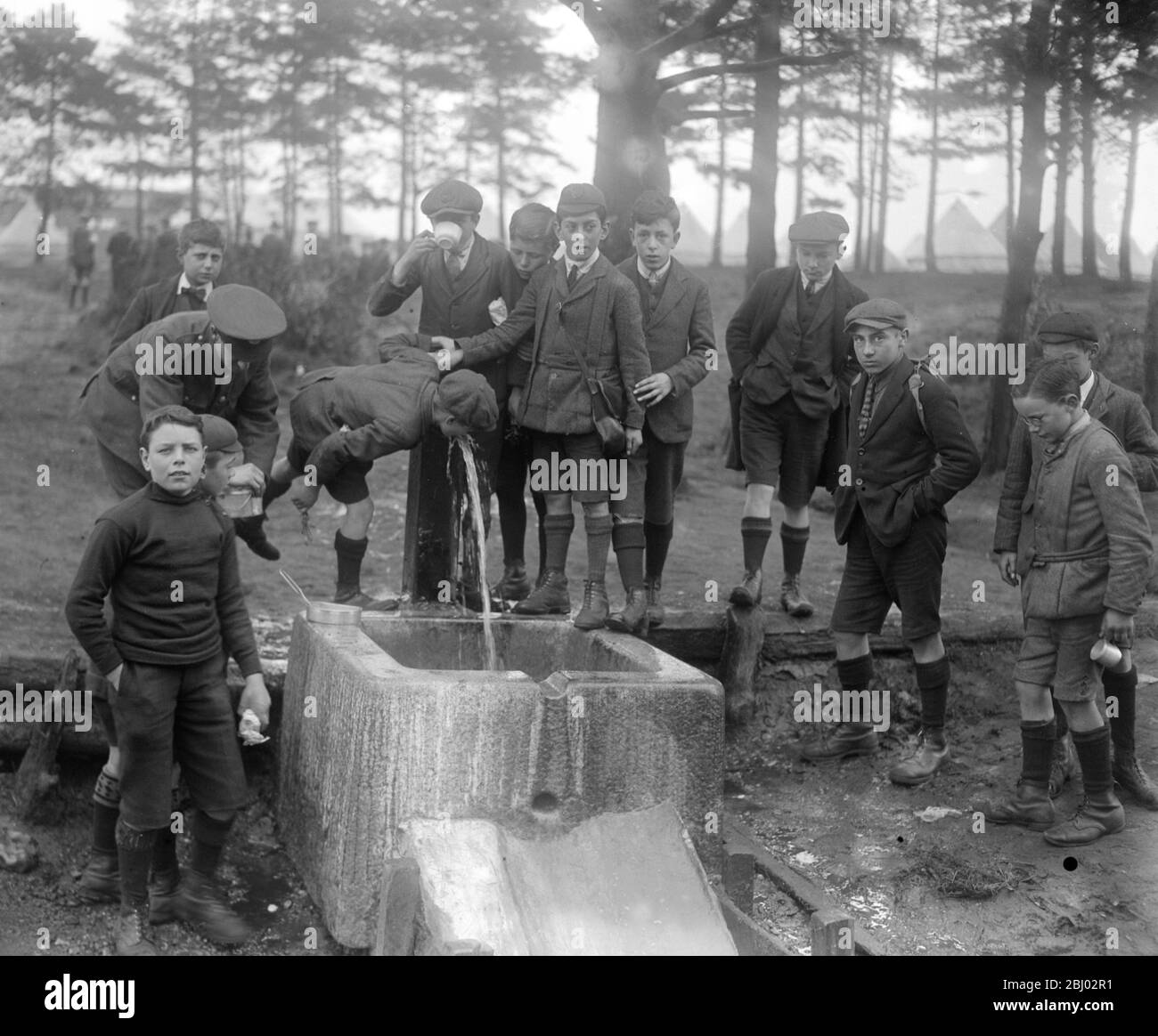 Mai Tag auf Wimbeldon Common - Boys of the West Hill School Wandsworth , Probenahme des Wassers bei Ceasars gut Wimbeldon gemeinsame , ein Mai Tag Brauch , die wiederbelebt wurde , soll eine gute Gesundheit für das kommende Jahr zu gewährleisten - 2 Mai 1921 Stockfoto