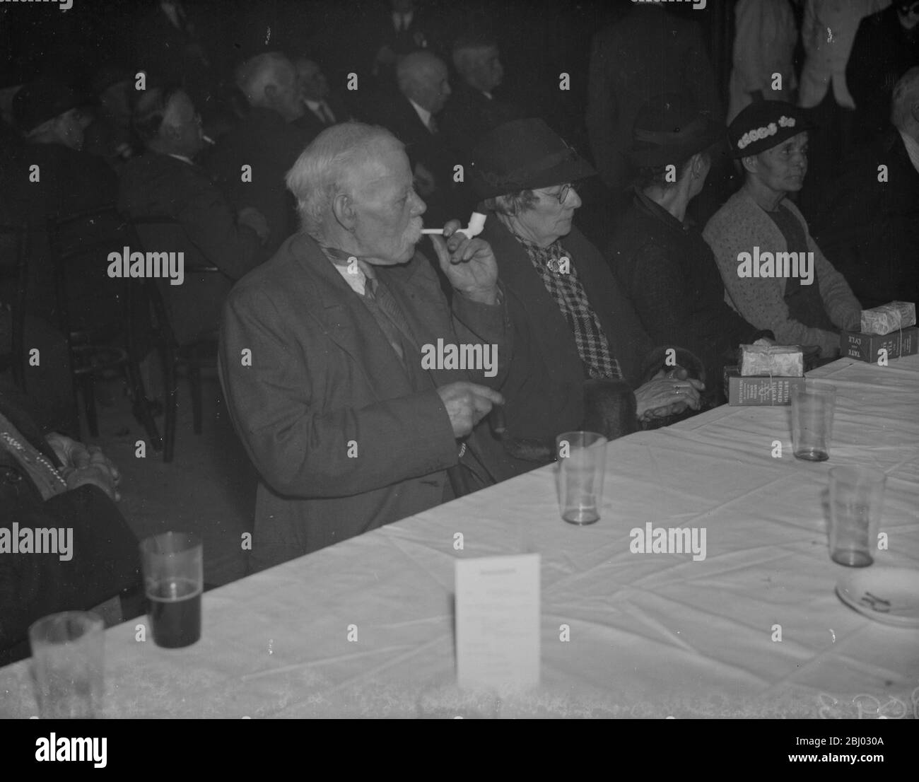 Ein älterer Herr raucht seine Tonpfeife auf der alten Leute Party in Crayford, Kent. - 1. Februar 1938 Stockfoto