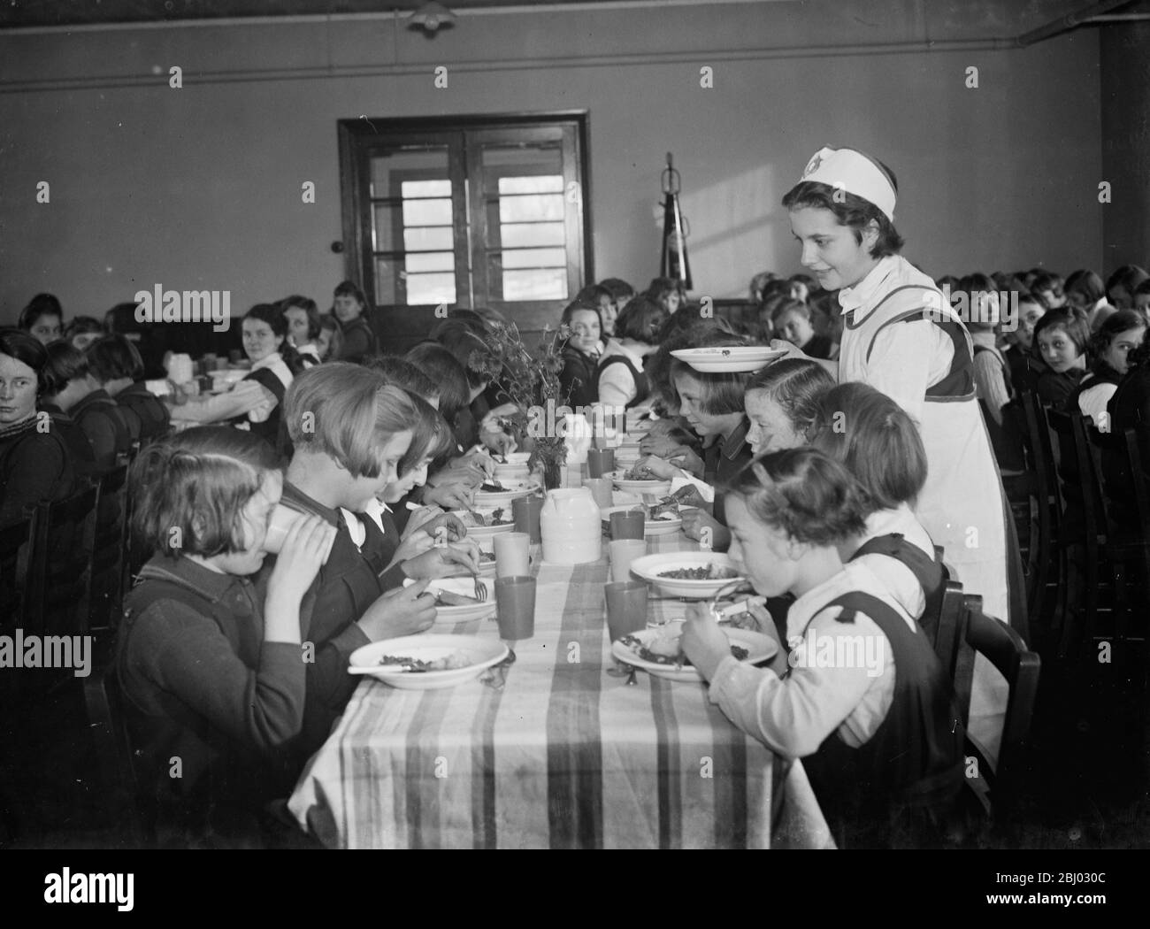 Die Dame mit Abendessen serviert Mittagessen in einer Mädchenschule in Orpington, Kent. - 1937. Stockfoto