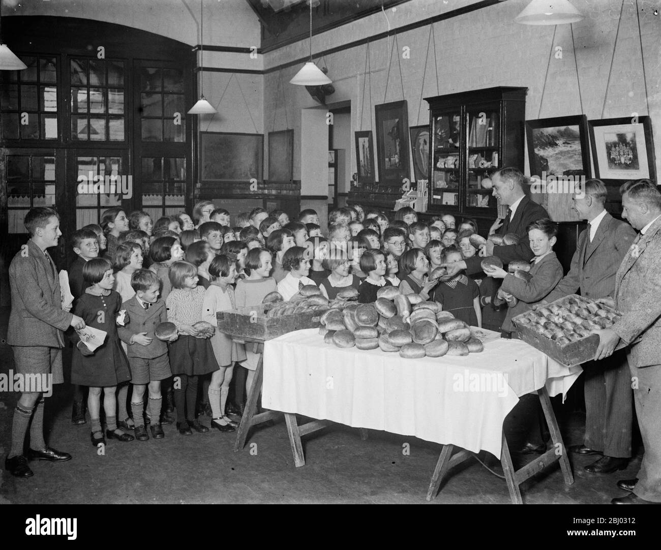 Junge Schulkinder erhalten eine Lieferung von Brötchen von der Guy Fawkes Charity . - 1935 Stockfoto