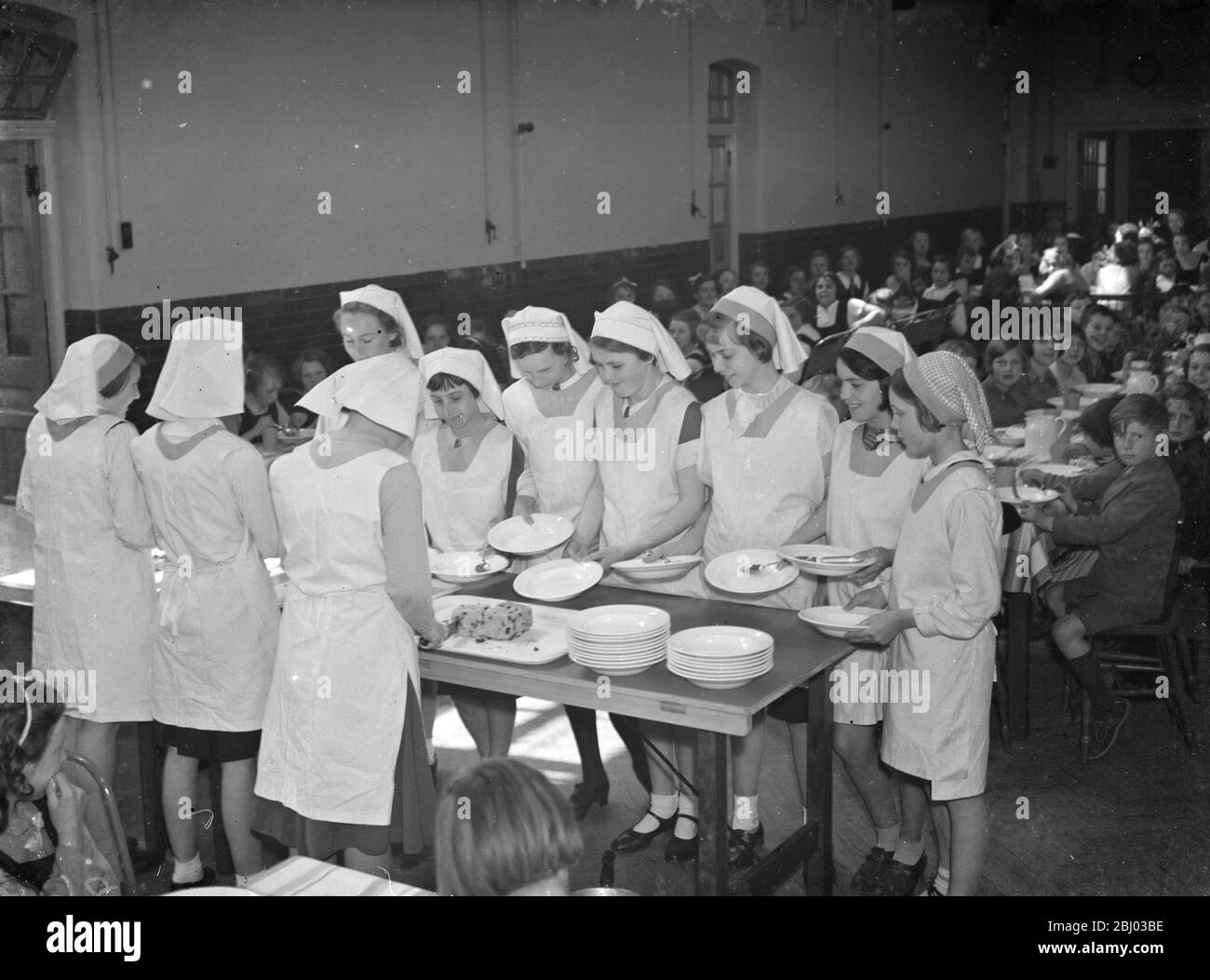 Abendessen in der East Central School in Dartford, Kent. - die Mädchen stehen ihr Essen an. - 1938 Stockfoto