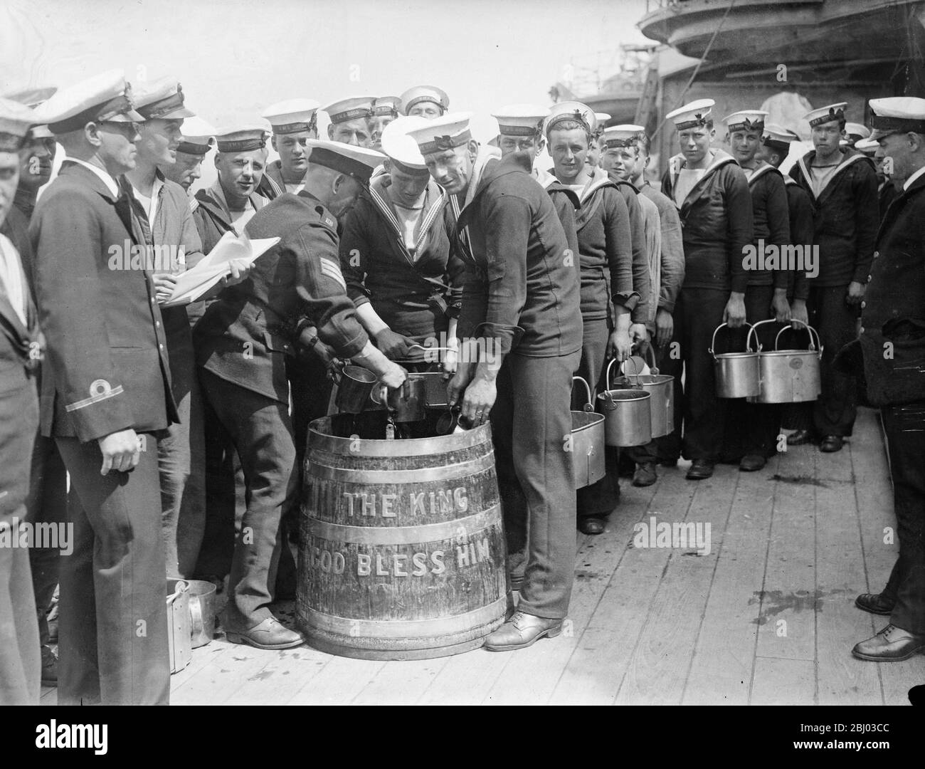 Matrosen an Bord HMS Hood (Wimpel Nummer 51) stehen in der Linie, um Rum-Ration in Vorbereitung des Trinkens zu ziehen, um die Gesundheit des Königs. - 15. Juli 1935 - - Stockfoto