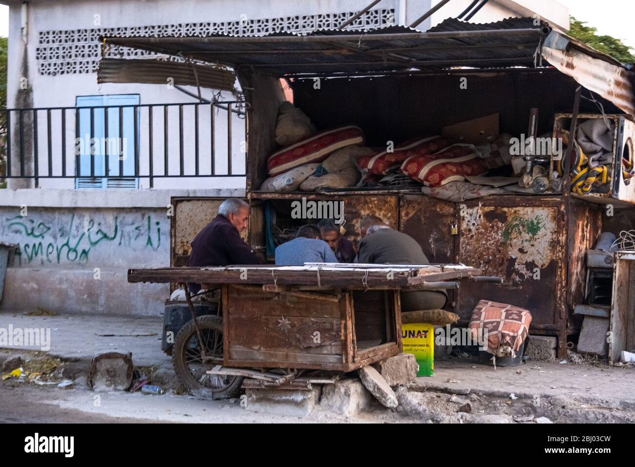 Ältere Männer treffen sich in einem Gefechtshaus auf einem Straßenhändler in Qamischli, Syrien. Stockfoto