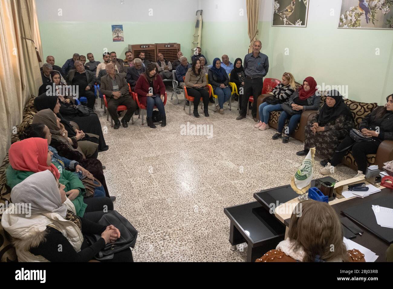 Ein Treffen der Gemeinde, bei dem die Bewohner über die jüngsten Kämpfe und Konflikte mit der Türkei diskutieren. Qamischli, Syrien. Stockfoto