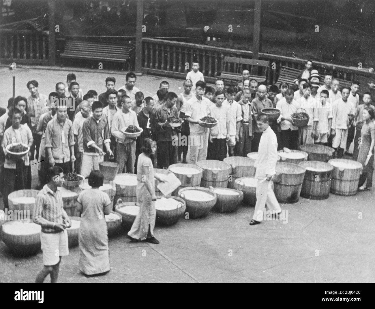 Nahrung für Kriegsopfer. - eine Reihe von großen Schalen mit Lebensmitteln gefüllt, die die Augen der hungrigen chinesischen Flüchtlinge erfreut, die ihre Rationen in Shanghai erwartet. - 25. November 1937 Stockfoto