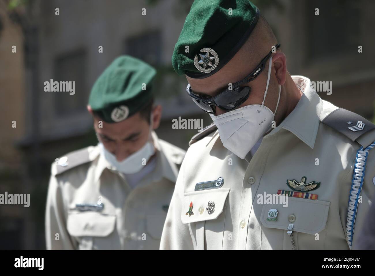 Jerusalem, Israel am 28. April 2020 steht ein israelischer Grenzpolizisten mit Schutzmaske wegen der COVID-19-Coronavirus-Pandemie in der Innenstadt von Jerusalem still, während eine Sirene zwei Minuten lang in Erinnerung an gefallene Soldaten und Opfer des Terrorismus am offiziellen Gedenktag Israels ertönt. Stockfoto