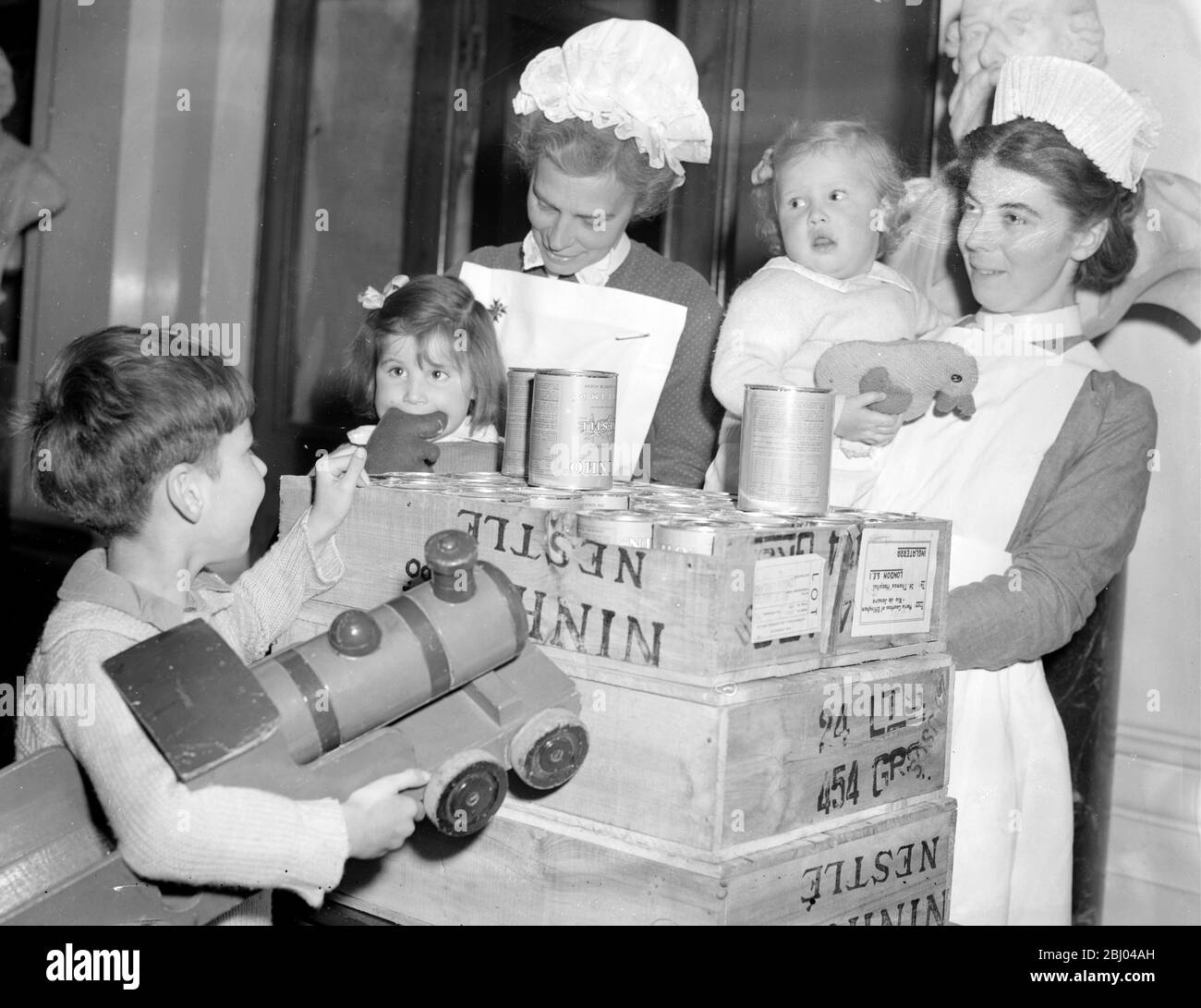 Eine Ladung Lebensmittelpakete für britische Krankenhäuser aus Brasilien werden in das St. Thomas's Hospital geschickt. - Schwester Lillian und Schwester Seymour mit einigen Kindern des St. Thomas's Hospital, die heute einige der Lebensmittelpakete erhalten. - 13 September 1948 - - - - - - - - - - - - - - - - - - - - - - - - - - - - - - - - - Stockfoto