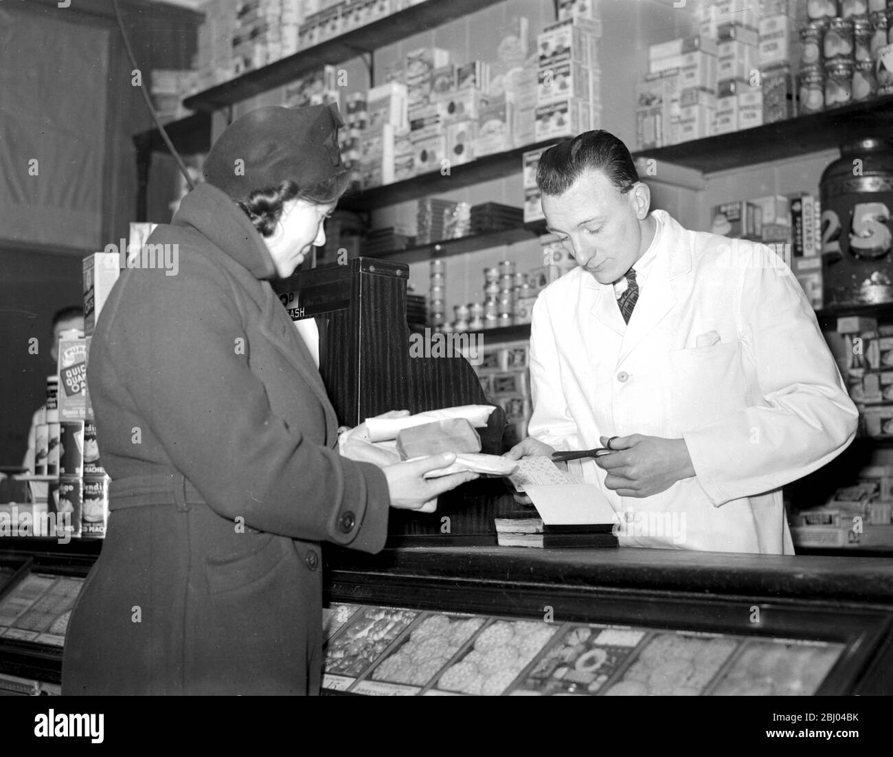Krieg 1939-1940. - Rationierung - Ausschneiden der Gutscheine für Zucker im Lebensmittelgeschäft. - 8. Januar 1940 Stockfoto
