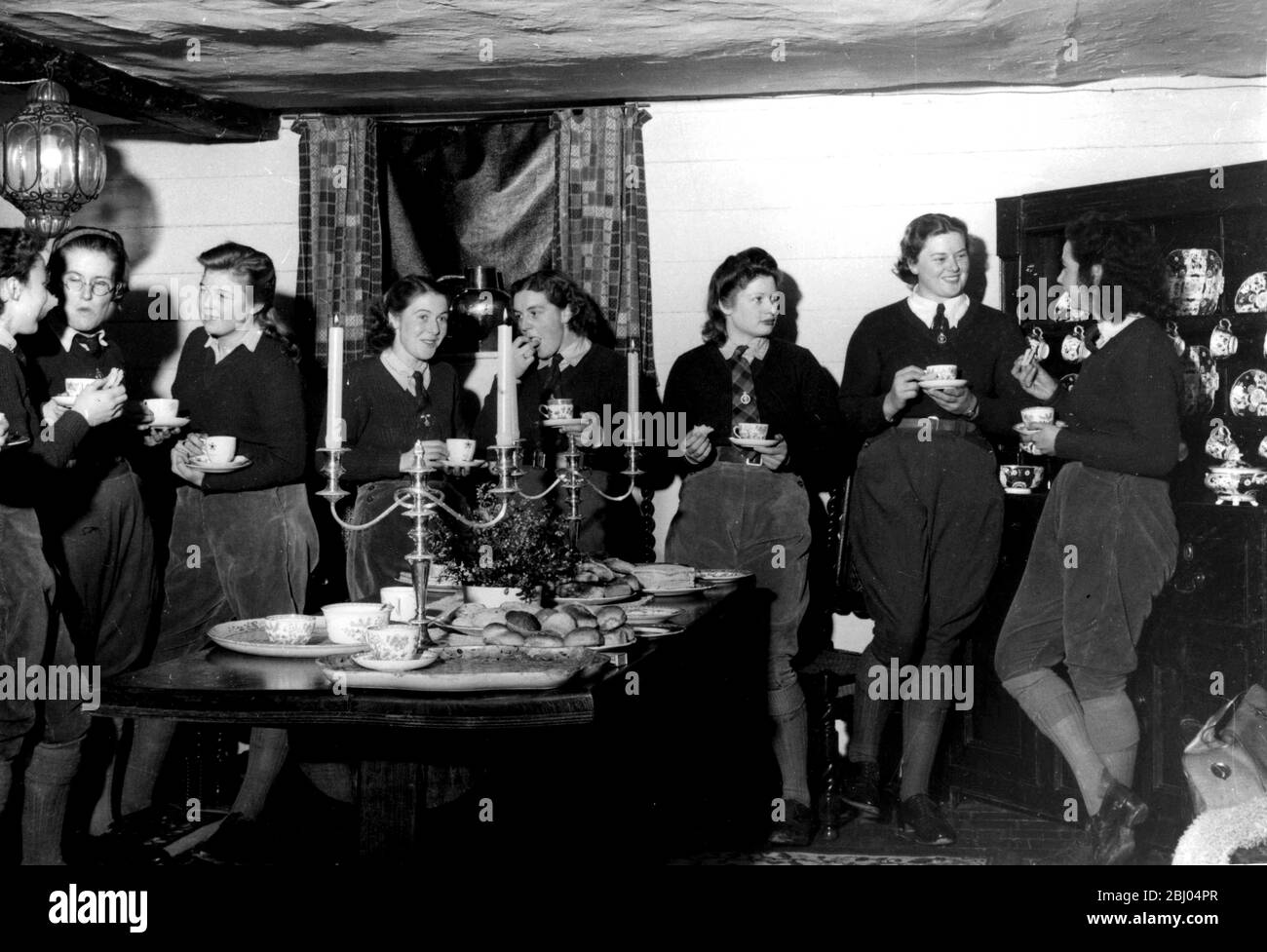 WW2: Gossipping und Kaffee und Sandwiches. Jeden Montag in einem 400 Jahre alten Ferienhaus, in Friedenszeiten von Mabel Constanduros, das radio star belegt, gibt es eine informelle Zusammenkunft von Land Mädchen. Stockfoto