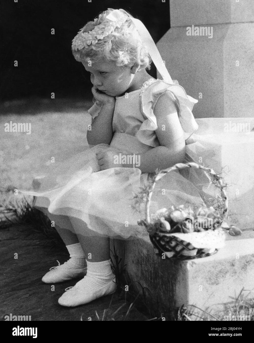 Eine kleine Brautjungfer müde warten auf die Erwachsenen. Eltham 1958 Stockfoto