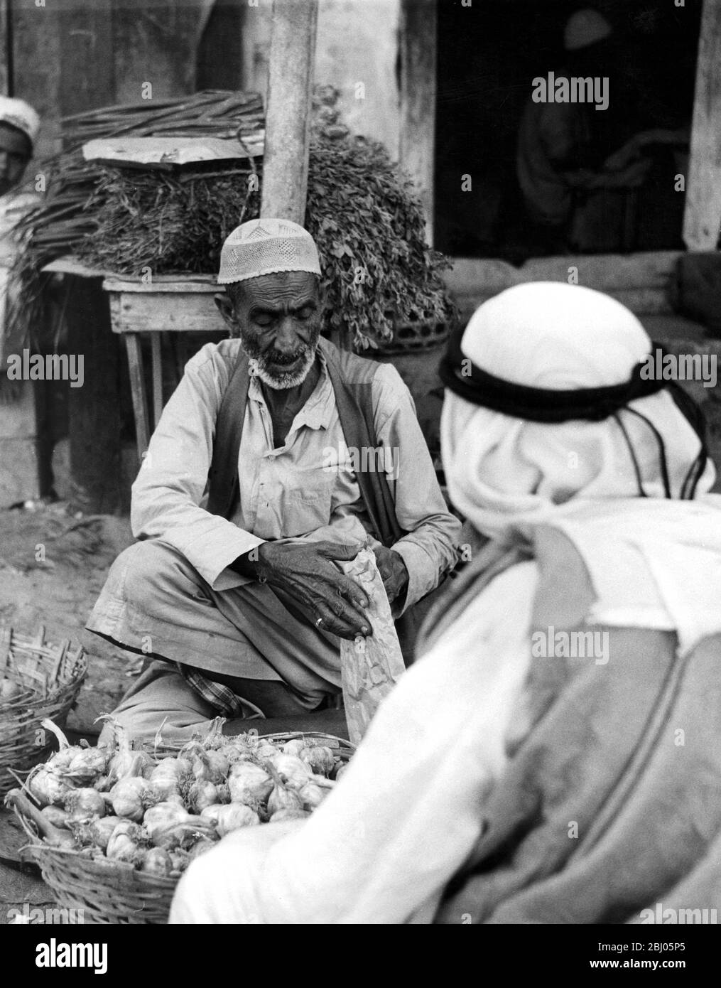 Mann, der Knoblauch in einem Souk von Dubai tradet - - Stockfoto