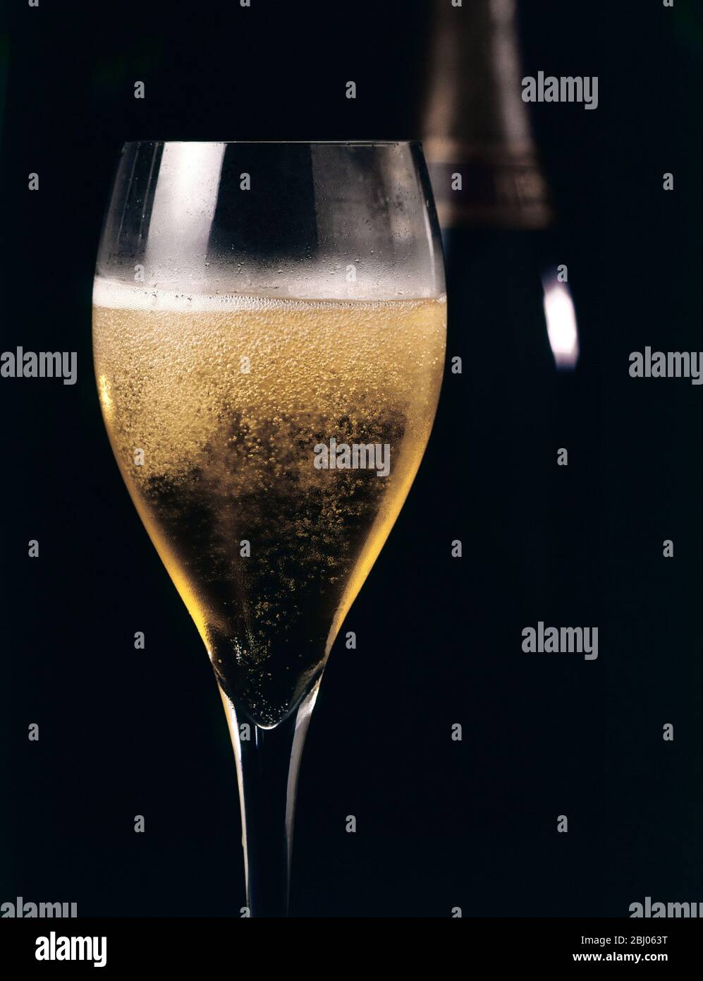 Champagner in Tulpenform vor dunklem Hintergrund Stockfoto