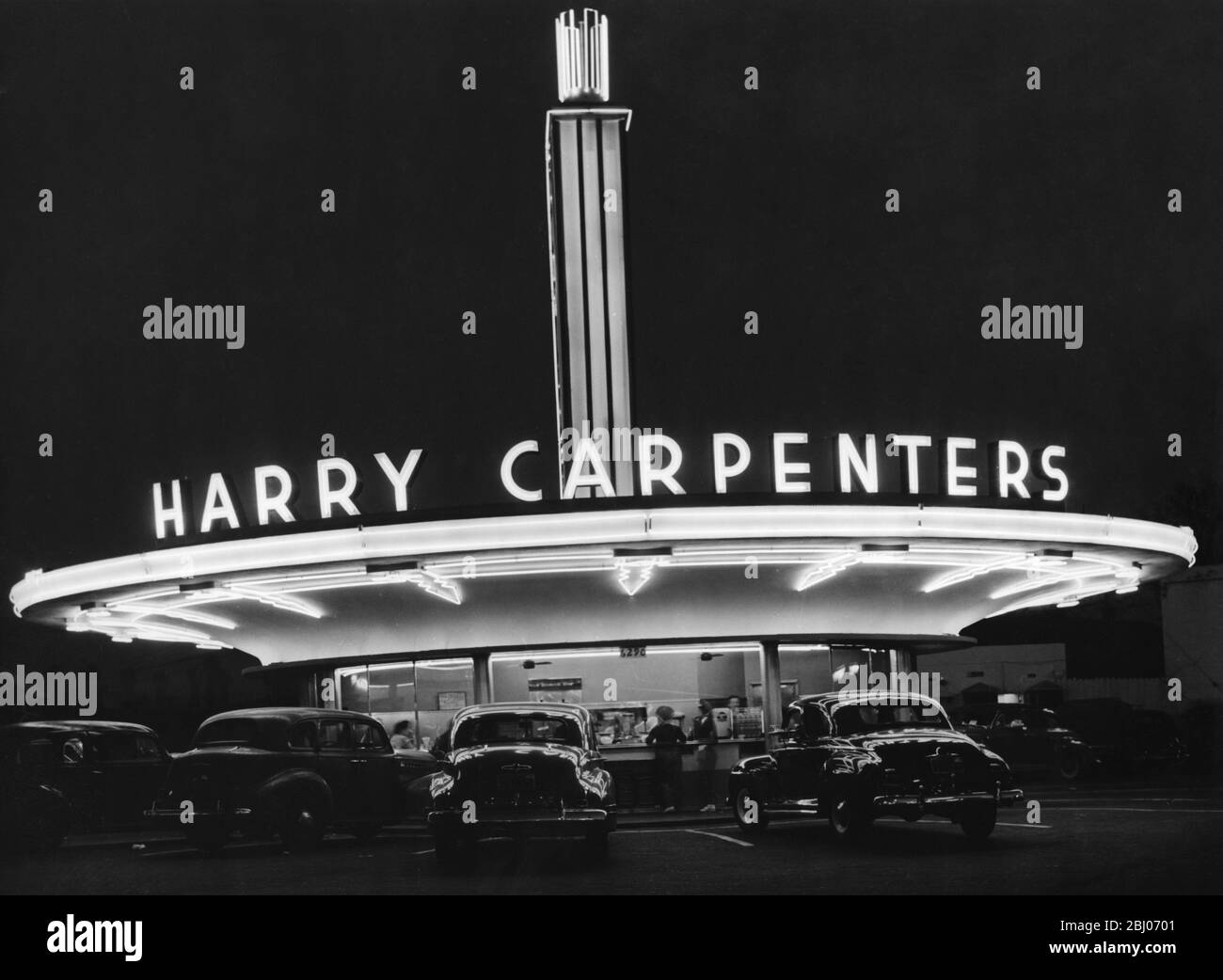 An der Ecke von Hollywoods Sunshine Boulevard und Vine Street , Stand Harry Carpenters Drive-in , die den gleichen Service bei Nacht unter den Neon-und Leuchtstofflampen bieten Stockfoto