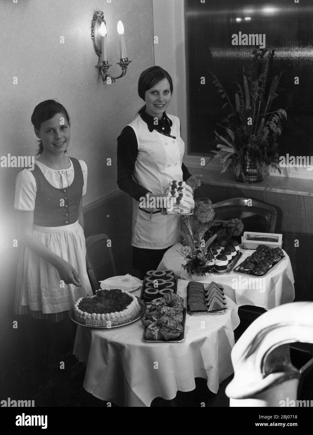 Österreichisches Café mit Kellnerinnen, die Kuchen zeigen Stockfoto