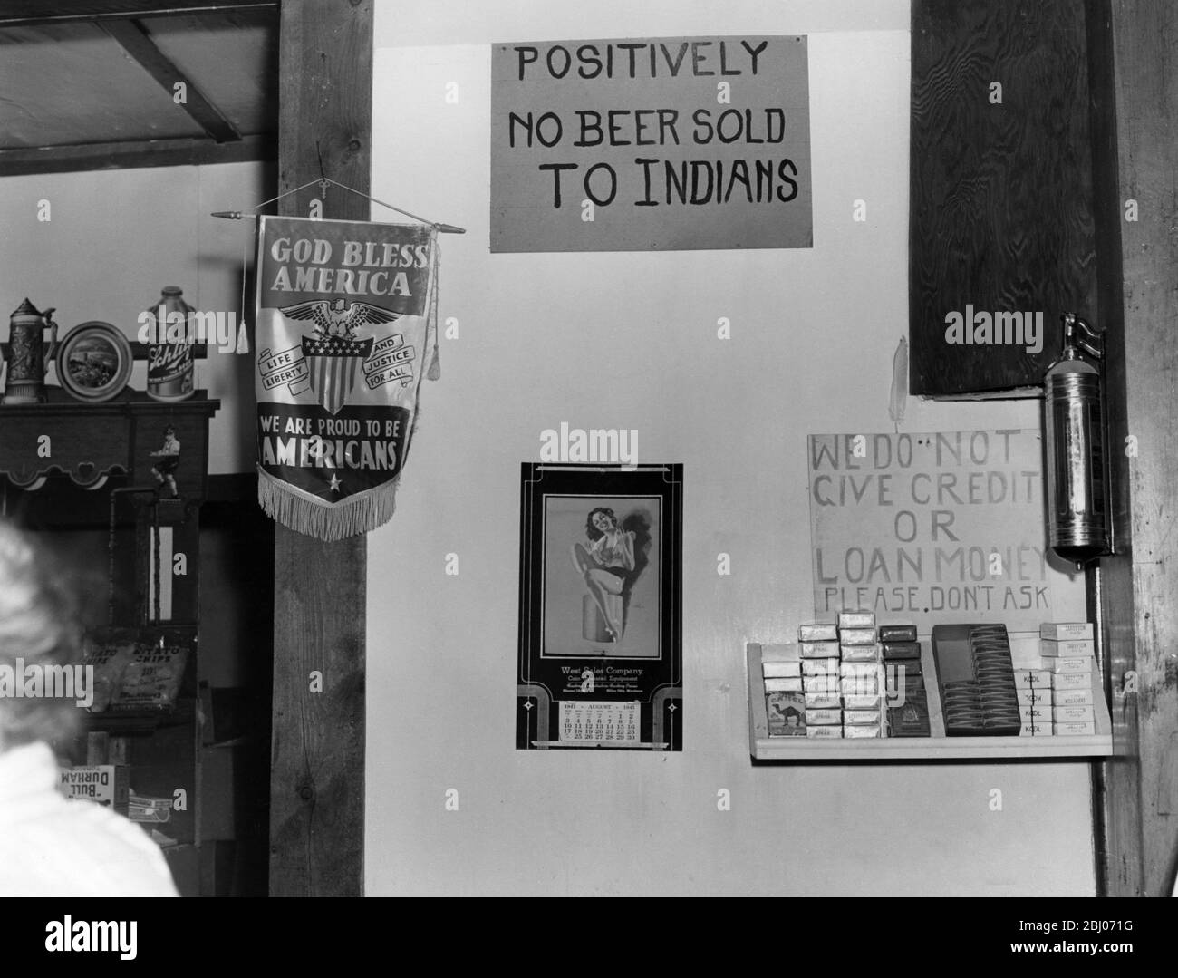 Interieur einer amerikanischen Bar mit Schilderaufschrift: Positiv kein Bier verkauft an Indianer, und ein anderes Wir geben keine Kredit-oder Darlehen Geld, bitte nicht fragen. - August 1941 Stockfoto