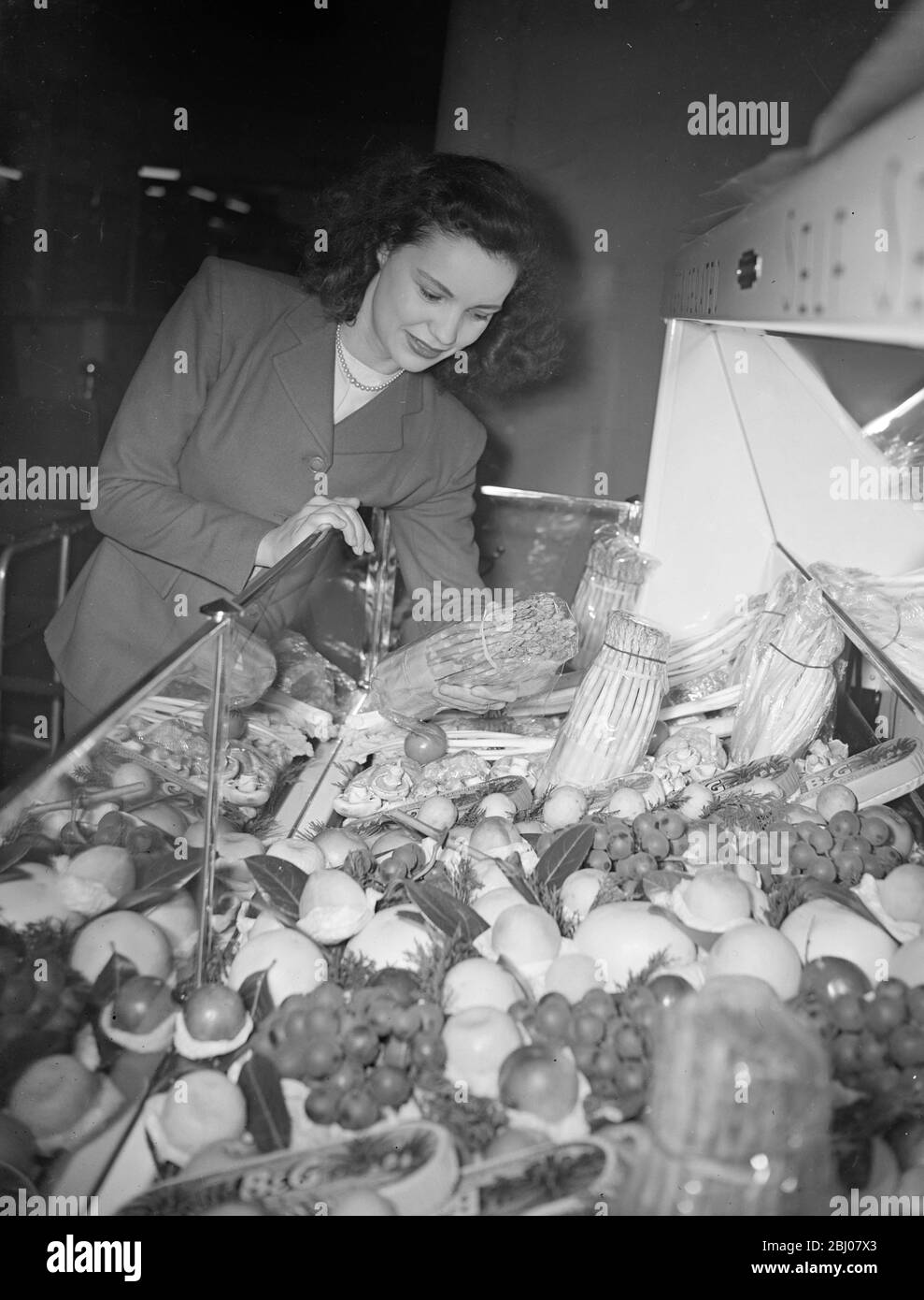 Die heute in Olympia von Herrn Harold Wilson, dem Präsidenten des Handelsausschusses, eröffnete Hotel-, Restaurant- und Catering-Ausstellung zeigt viele Vorteile bei der Zubereitung von Speisen, die durch die Einführung der Wissenschaft in der Küche erreicht werden. - Neue Elektrogeräte und die Einführung von Tiefkühlkost aus Amerika sind Merkmale der Ausstellung. - Bilderschau: Miss Helen Flaxman bewundert die Ausstellung von Milchgemüse und Obst, die heute in der Hotel-, Restaurant- und Catering-Ausstellung in Olympia zu sehen ist. - 16. Januar 1948 Stockfoto