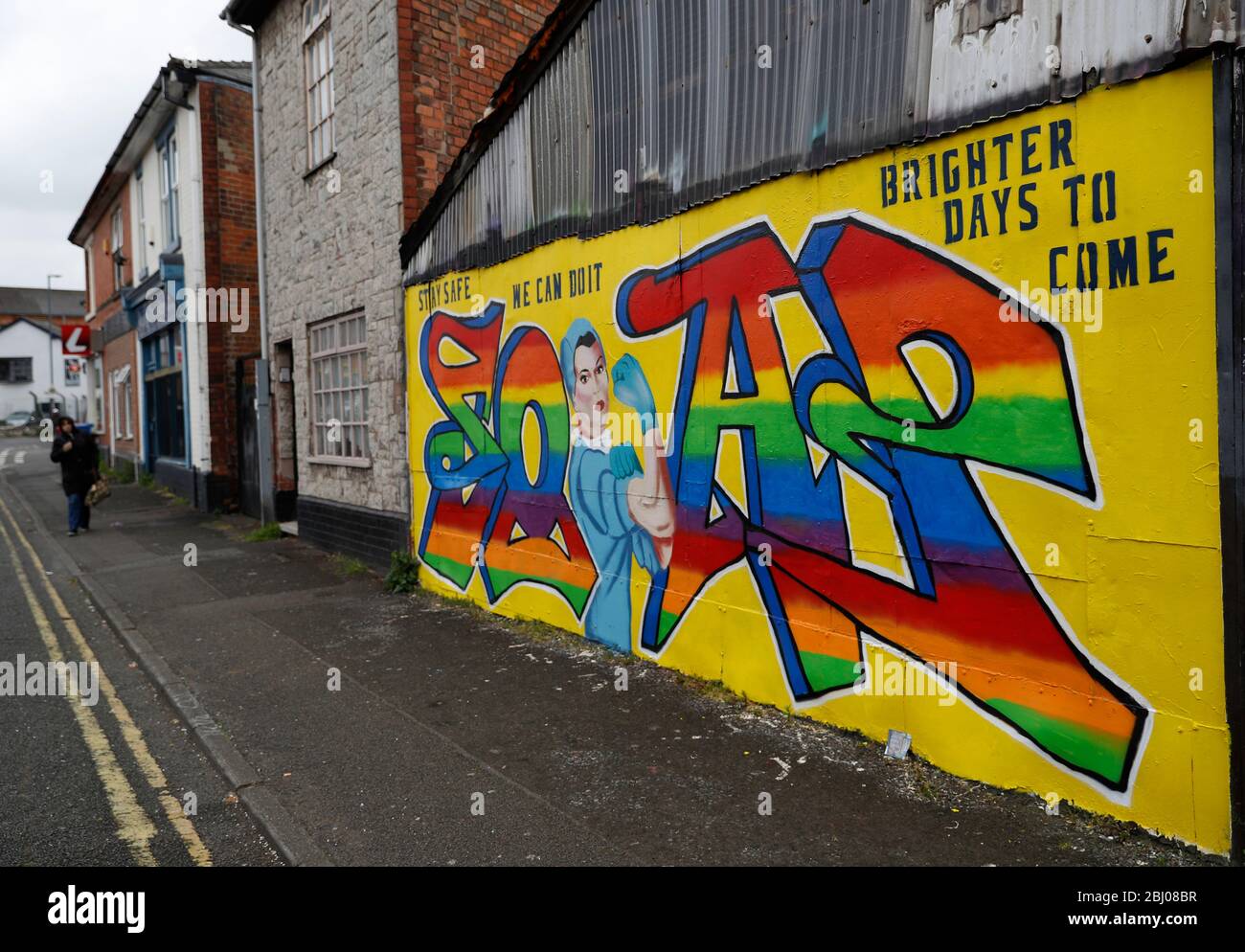 Derby, Derbyshire, Großbritannien. April 2020. Eine Frau geht während der Sperrung der Coronavirus-Pandemie in Richtung Covid-19-Straßenkunst. Credit Darren Staples/Alamy Live News. Stockfoto