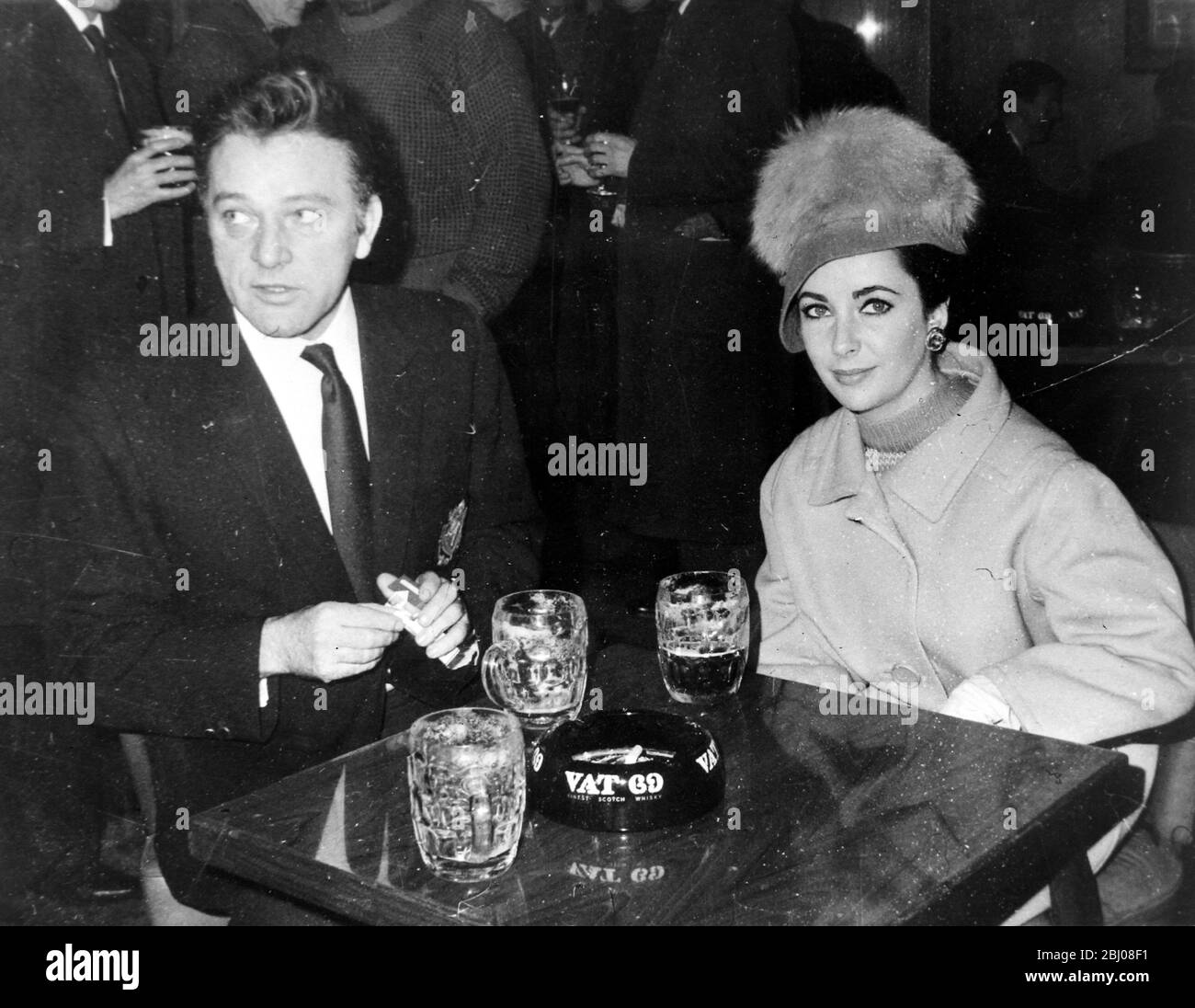 Richard Burton und Elizabeth Taylor teilen sich am Sonntag, den 17. Februar 1963, einen Tisch im Fox-on-the-Hill-Haus in Londons Danemark Hill. Elizabeth Taylor, die sich von ihrem Sänger-Schauspieler-Ehemann Eddie Fisher entfremdet, ist mit Burton in den VIPs, derzeit in Elstree, in der Hauptrolle. Liz, die kürzlich eine Knorpeloperation hatte, hinkte leicht, als sie den Pub verließ und in einen Rolls Royce stieg. Stockfoto