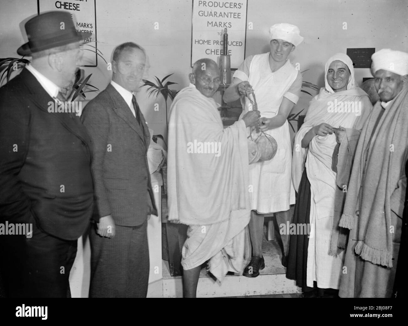 Mahatma Gandhi wird mit zwei Käsesorten aus Ziegenmilch während seines Besuchs auf der Dairy Show in den Royal Agricultural Halls, London vorgestellt. - 23. Oktober 1931 Stockfoto