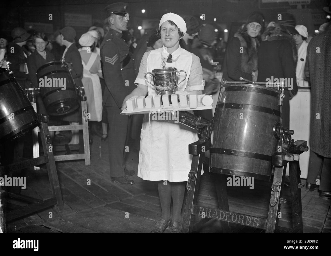 Miss Rosa Hancock, Champion Dairymaid in den Royal Agricultural Halls, Islington, London, mit ihrer Butter und ihrer Trophäe. - 1931 Stockfoto