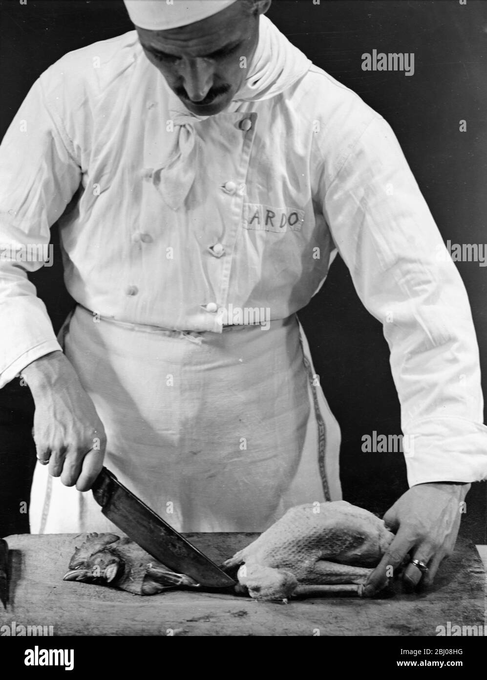 Ein Koch bereitet ein Huhn zum Kochen zu. - Mailand, Italien. - undated - Stockfoto