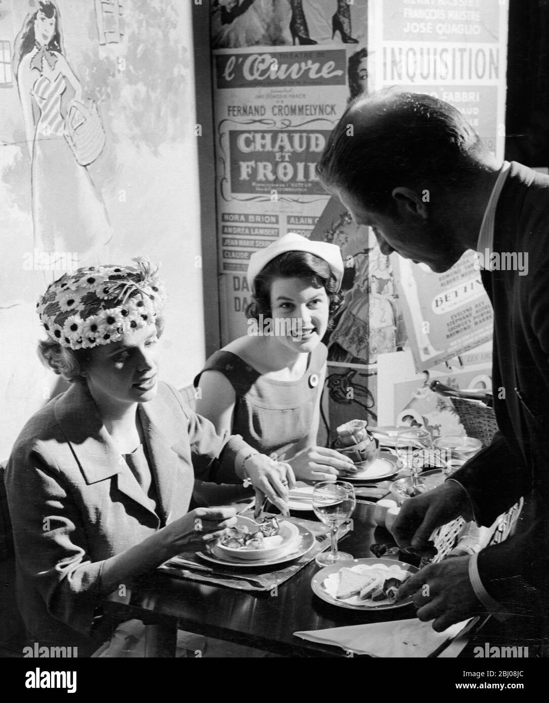 Ein Kellner serviert zwei Damen zum Mittagessen in Le P'tit Monmartre, Marylebone Lane, London, England - 9. August 1958 Stockfoto