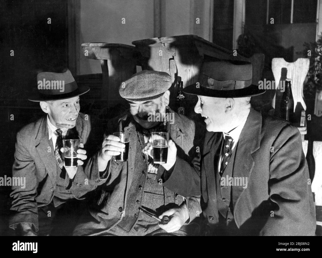 Drei Männer, die in einem Pub für Ernteehorkey-Tradition in Bury St Edmunds nähen - um 1938 - Stockfoto