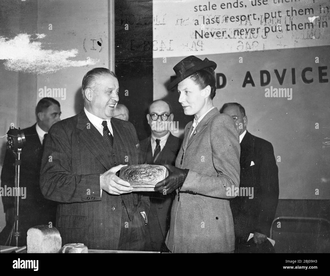 Die Rt. Sir Ben Smith, K.B.E., M.P., Minister für Ernährung, eröffnete die Ausstellung "Battle for Bread" auf dem bombardierten Gelände von John Lewis. - das Bild zeigt Sir Ben Smith und Dr. Edith Summerskill, M.P., Parlamentarische Staatssektion für das Lebensmittelministerium, die einen der New Economy Brote in der Ausstellung untersuchen. - 1. Mai 1946 Stockfoto