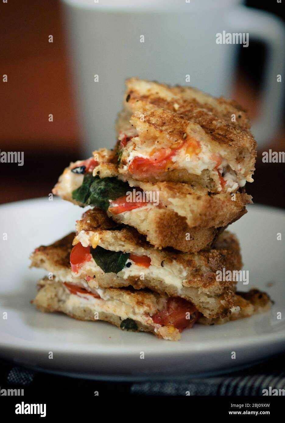 Geröstetes Sandwich aus glutenfreiem Brot mit Ziegenkäse Feta, Tomaten und Basilikum Stockfoto