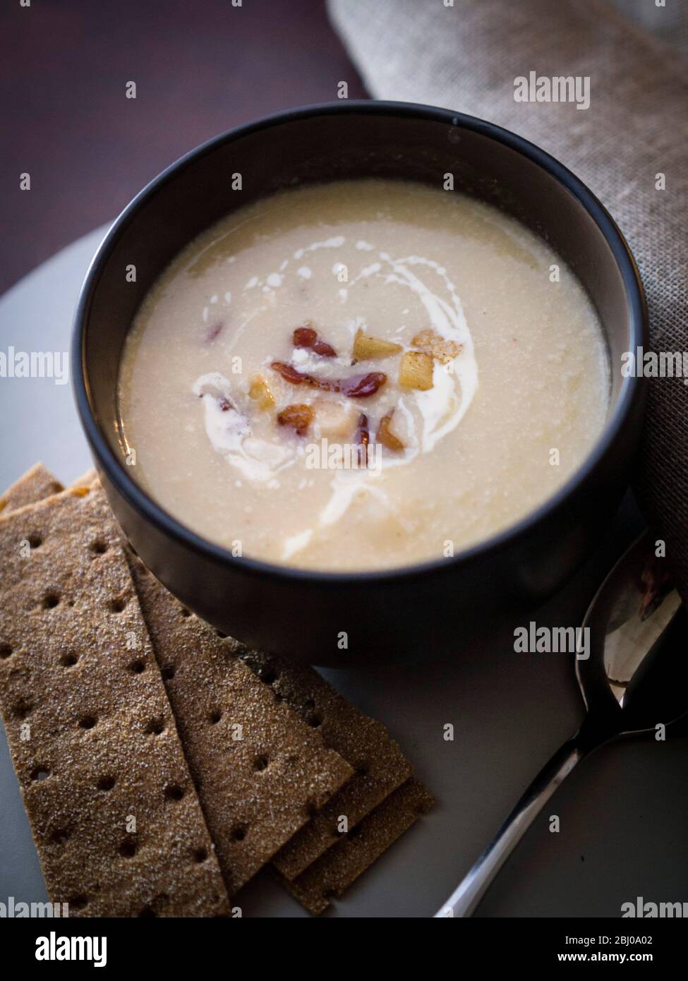 Sellerie und Blauschimmelkäse Suppe mit Beilage aus gebratenem Pancetta und Äpfeln Stockfoto