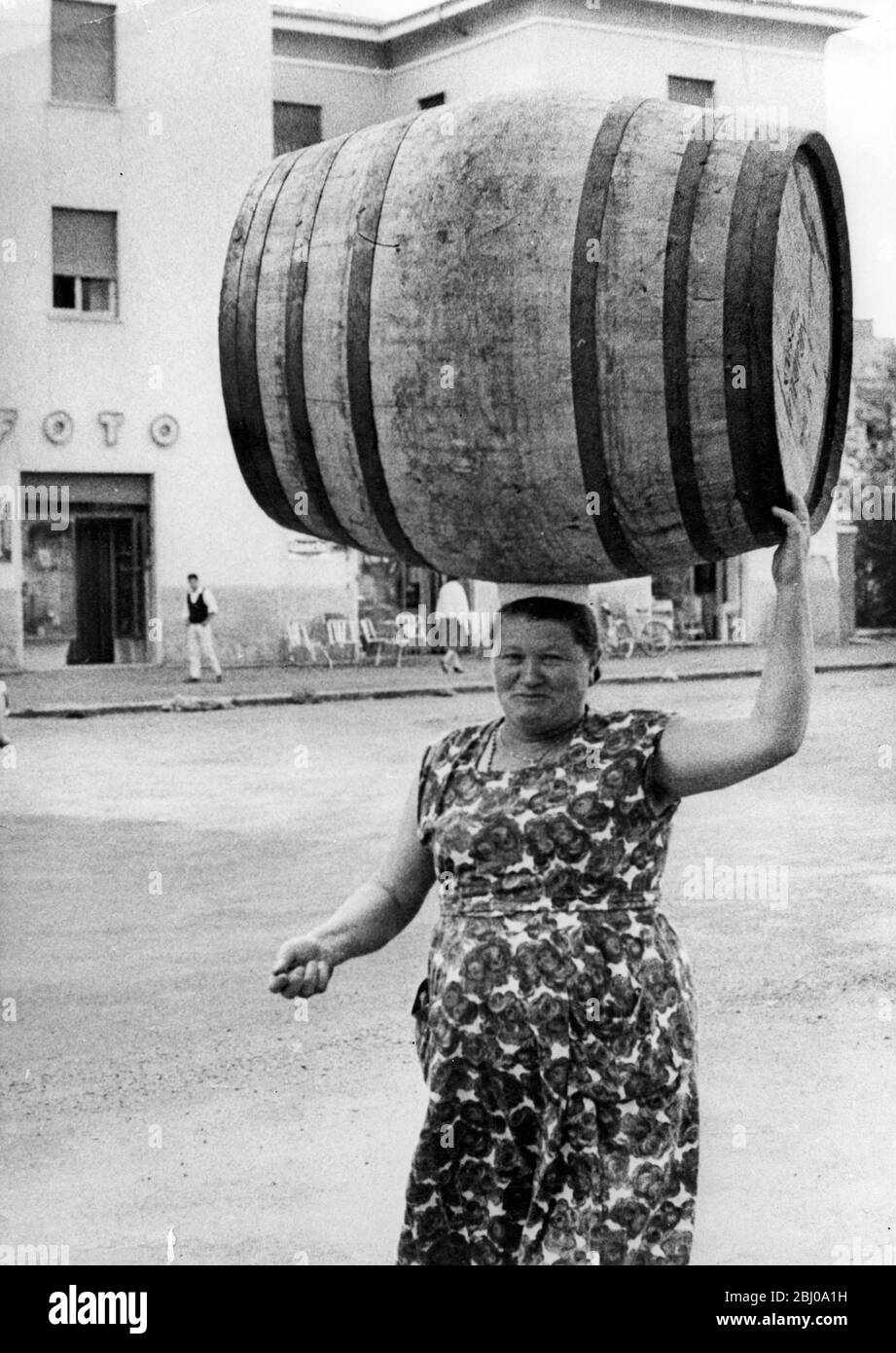 Eine Last auf ihrem Kopf - eine Frau von Marino, in der Nähe von Rom, Italien, trägt ein Fass auf ihrem Kopf in der traditionellen Weise - - 26. November 1960 Stockfoto