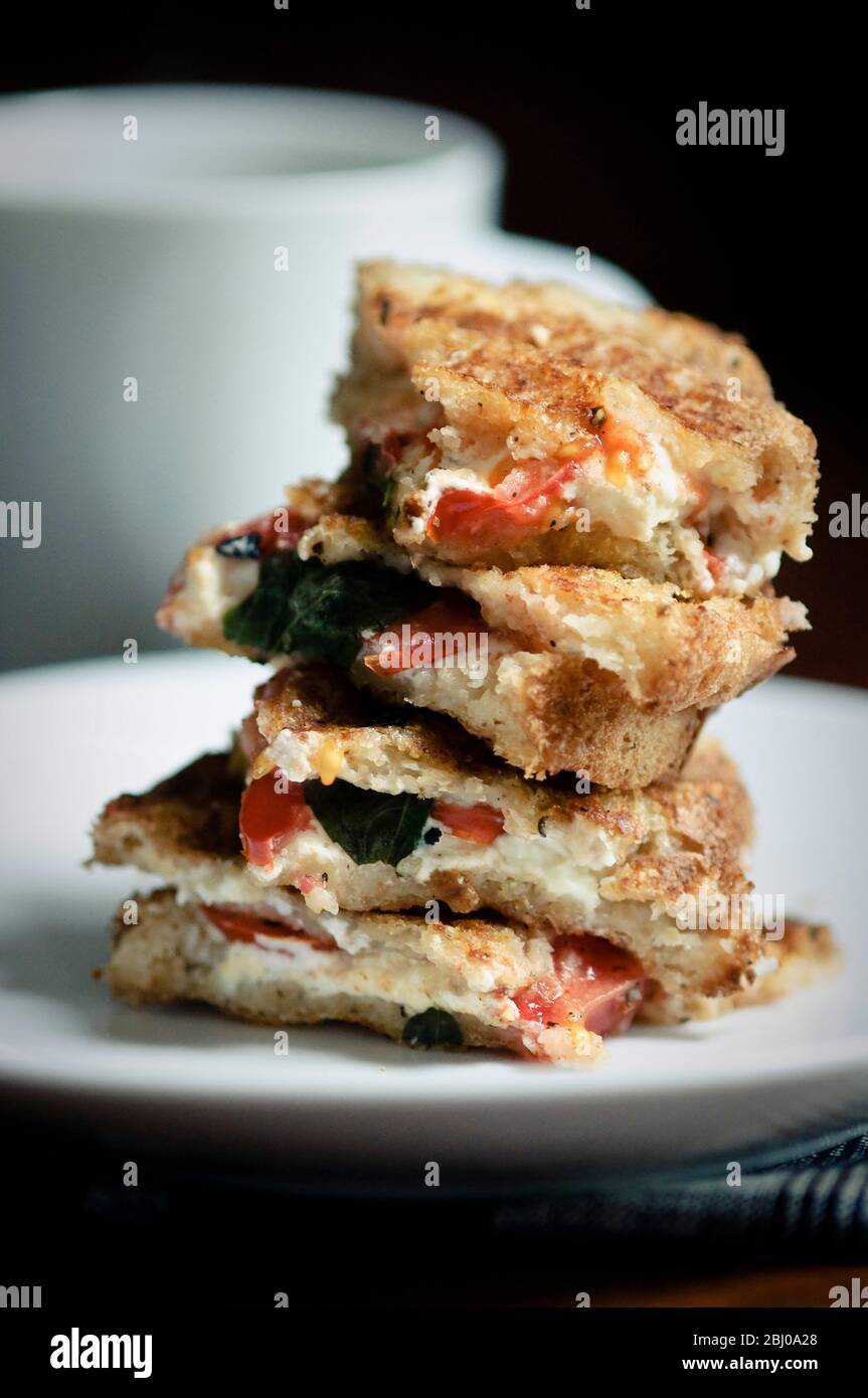 Geröstetes Sandwich aus glutenfreiem Brot mit Ziegenkäse Feta, Tomaten und Basilikum Stockfoto