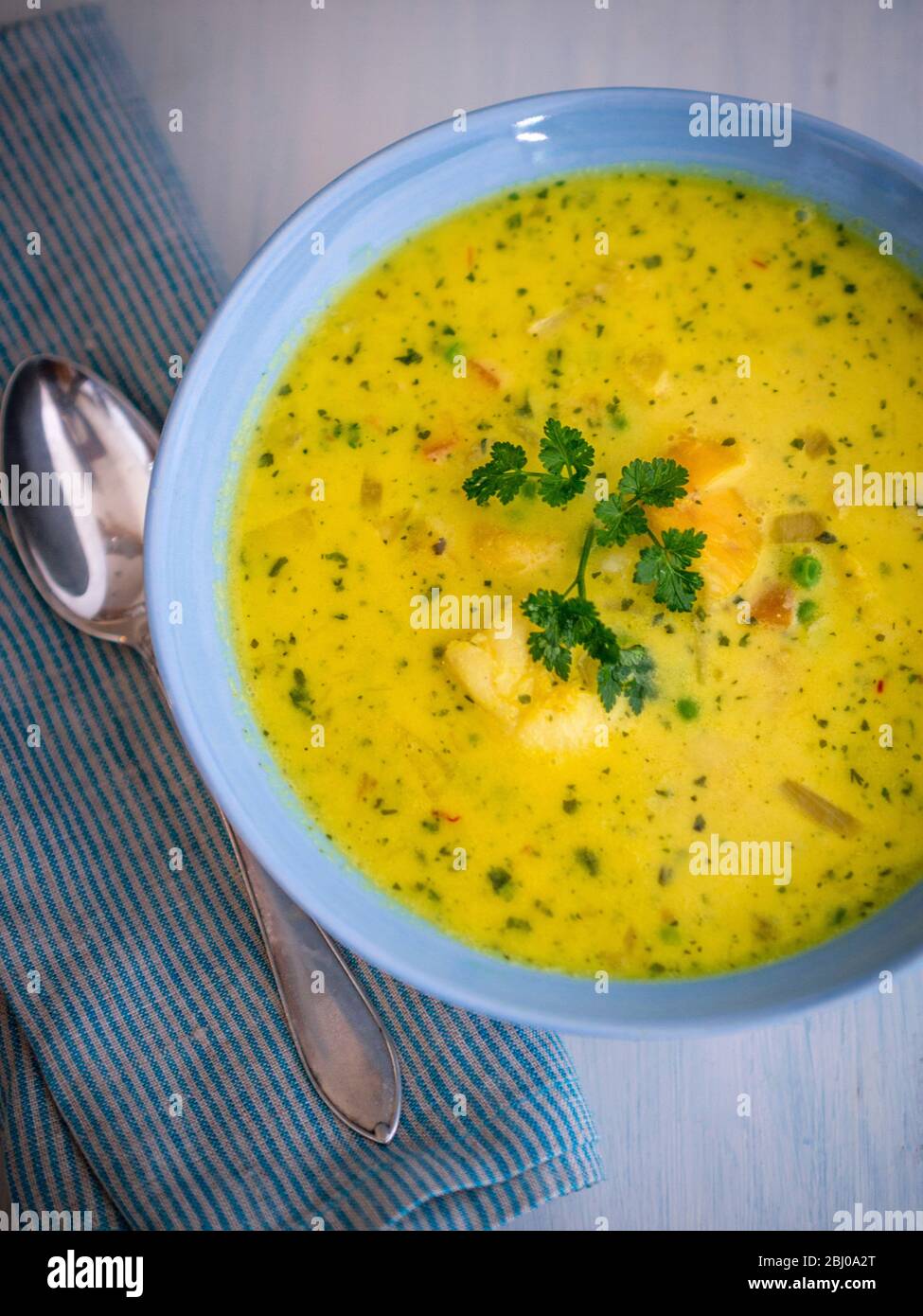 Schnelle und einfache Suppe/Eintopf von Gemüse mit Kabeljau-Stücken und Garnelen in safranduftender Brühe Stockfoto