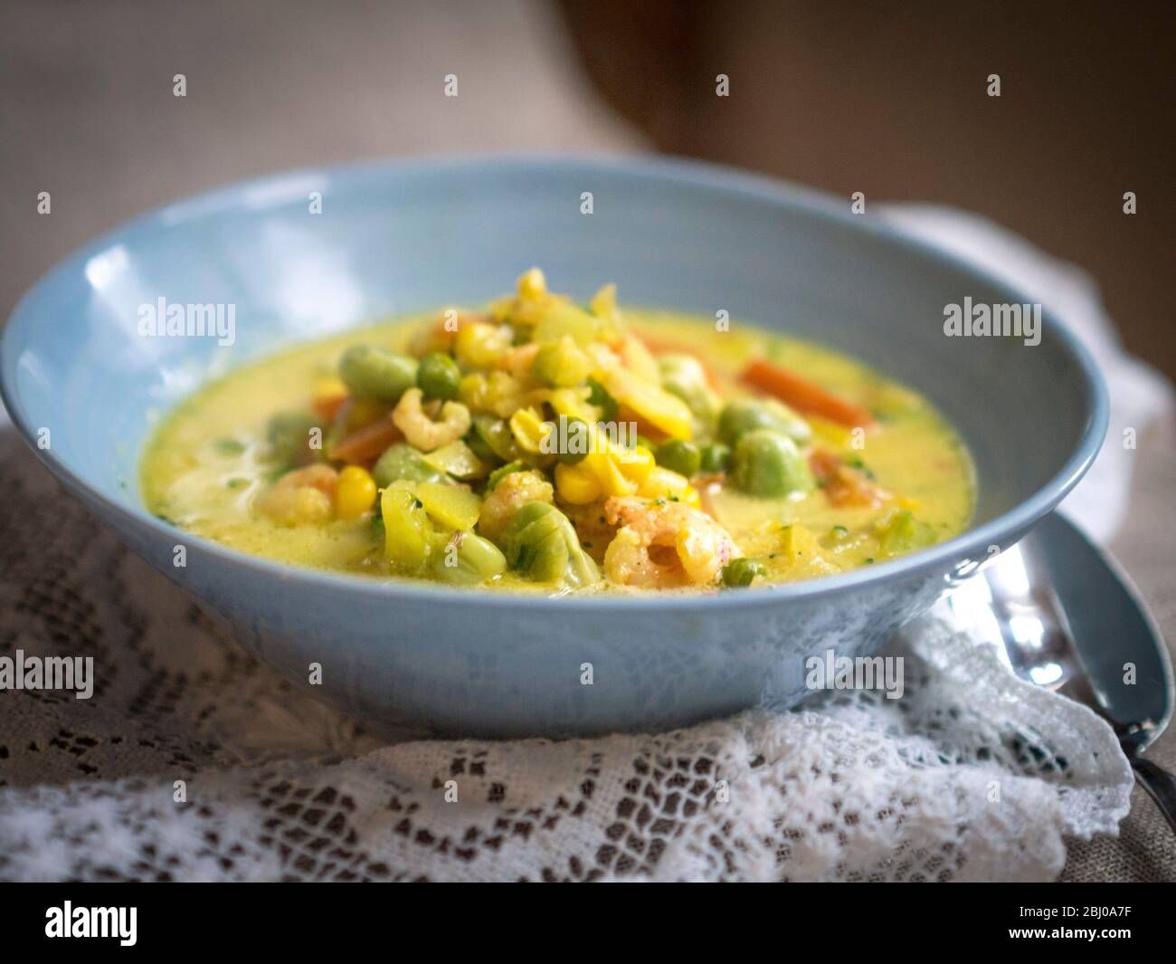 Schnelle und einfache Suppe/Eintopf von Gemüse mit Kabeljau-Stücken und Garnelen in safranduftender Brühe Stockfoto
