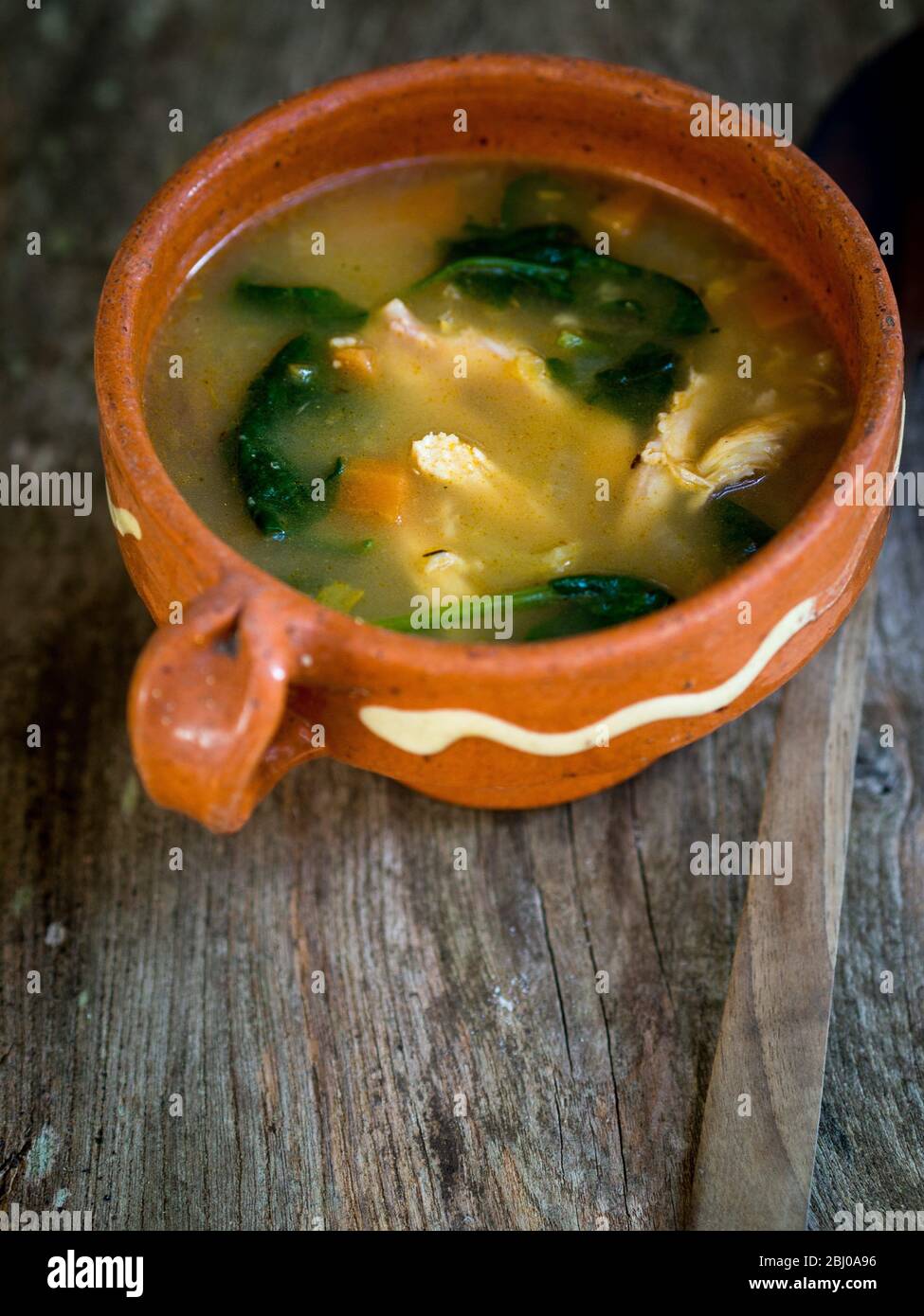 Komplette Mahlzeit Suppe von Huhn, Chorizo-Wurst und Gemüse mit braunem Reis, Linsen und Spinat, in blass blau Schüssel serviert Stockfoto