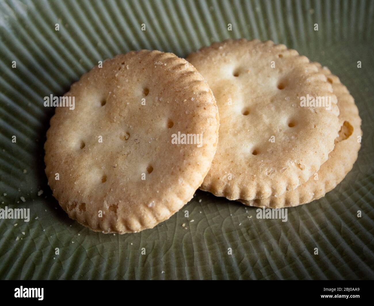 Gluten-freie Snack-Cracker auf grünen Teller Stockfoto