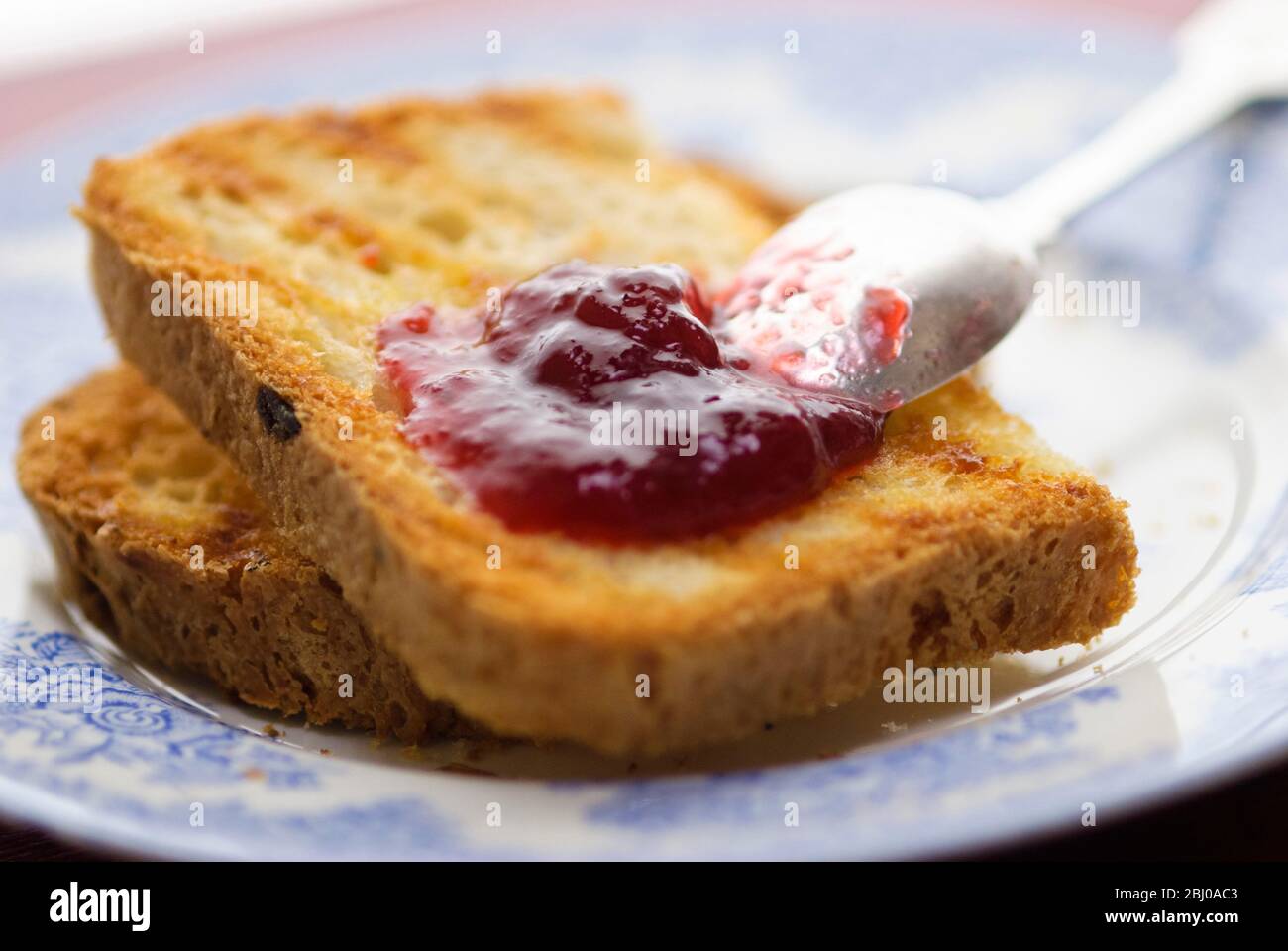 Hausgemachte Marmelade auf Toast aus glutenfreiem Brot mit silbernem Löffel gemacht Stockfoto