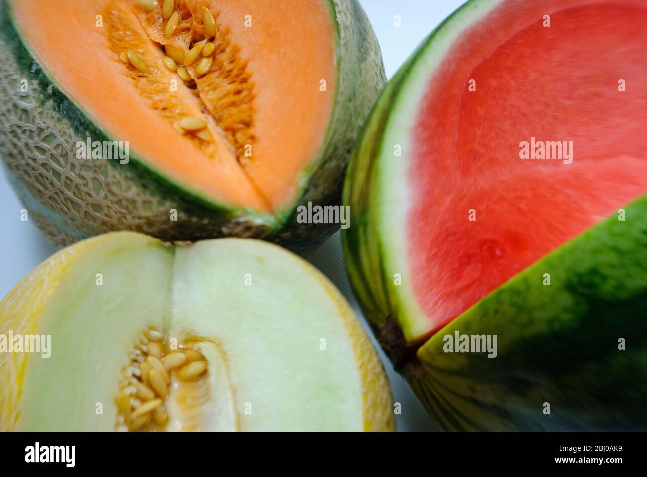 Drei verschiedene Wassermelonen, aufgeschnitten, um Farben zu sehen - Stockfoto