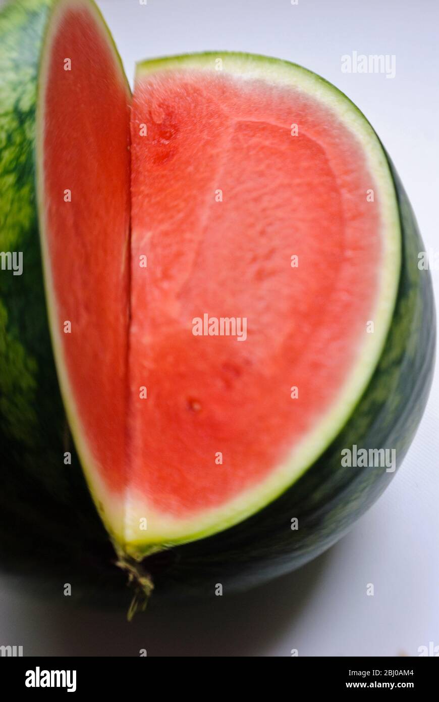 Schneiden Wassermelone zeigt rot im Fleisch - Stockfoto