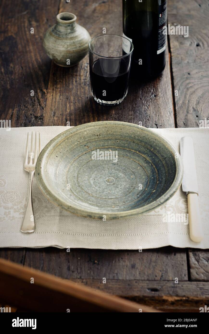 Rustikale Tischkultur mit einem Becher Rotwein vor dem Essen - Stockfoto