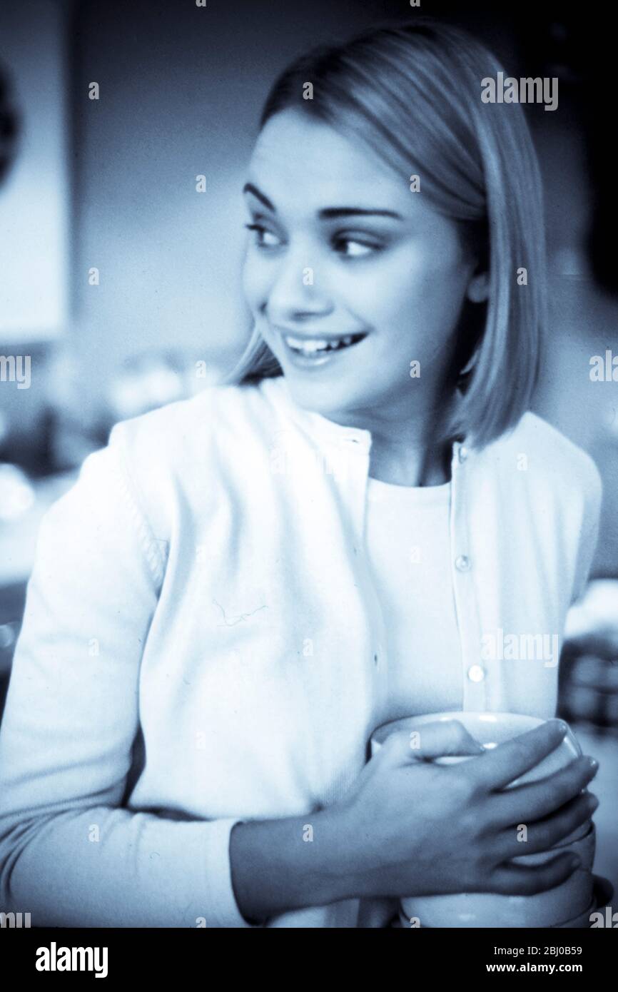 Mädchen in der Küche Einstellung mit einem Stapel von Tellern - Stockfoto