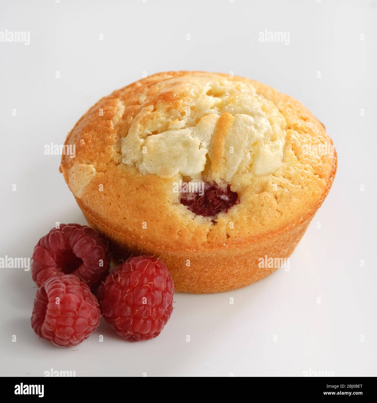 Muffin aus Himbeere und weißer Schokolade auf weißer Oberfläche - Stockfoto