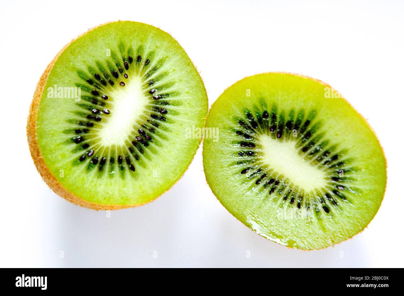 Halbierte Kiwi-Frucht auf weißem Hintergrund - Stockfoto