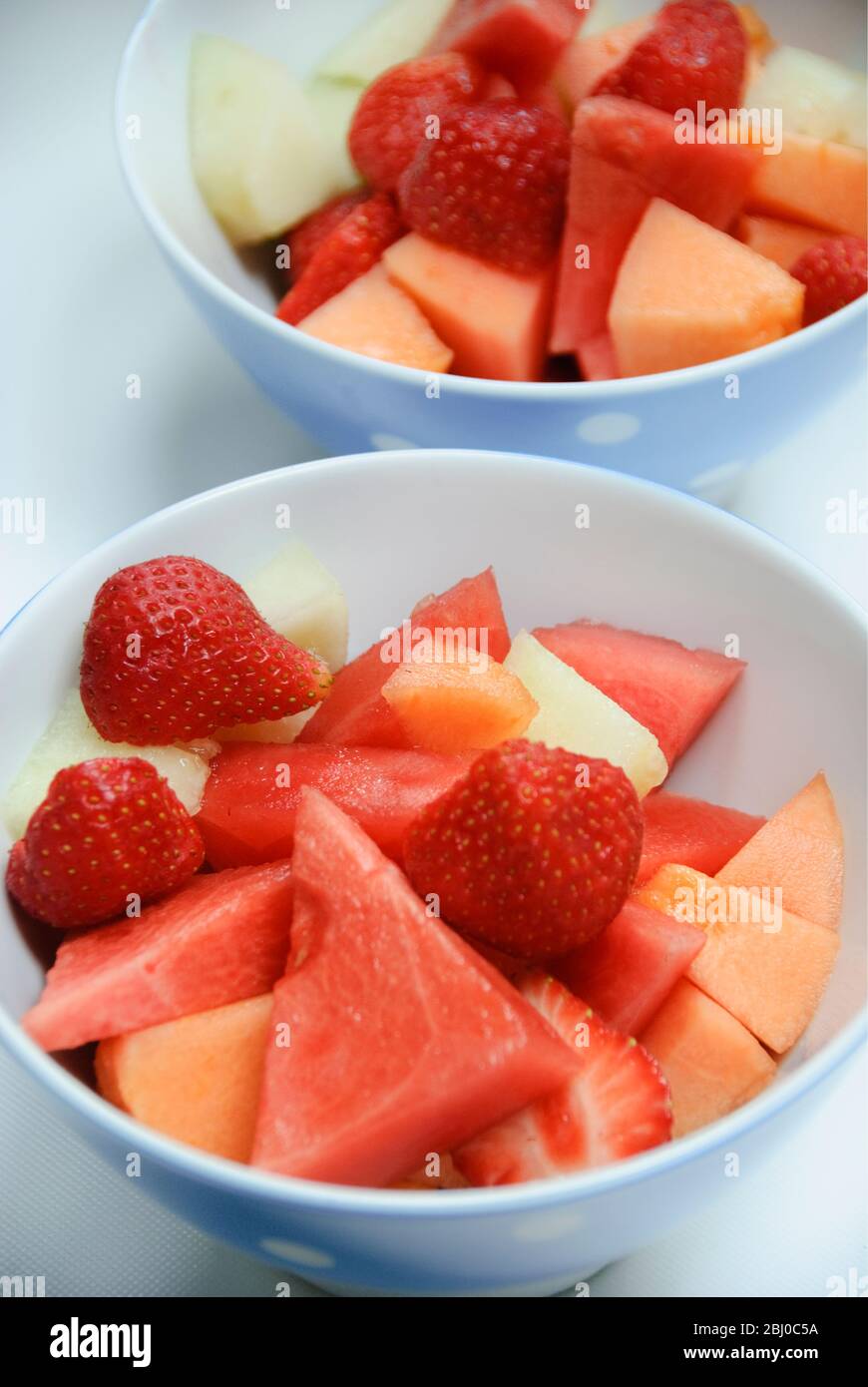 Frischer Obstsalat aus Stücken verschiedener Melonenarten mit Erdbeeren - Stockfoto