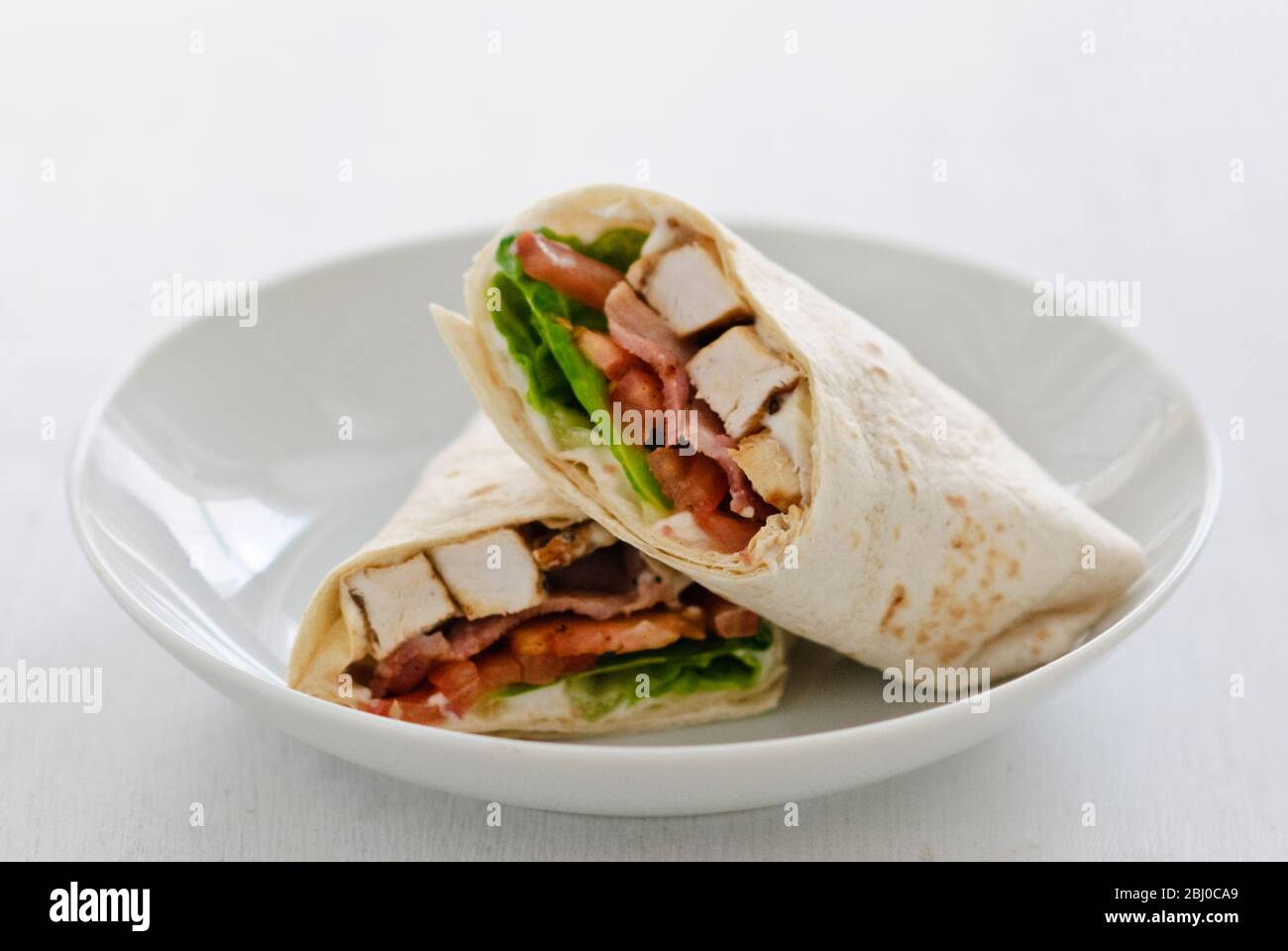 Sandwich Wrap mit Huhn, Speck, Tomaten und Salat - Stockfoto