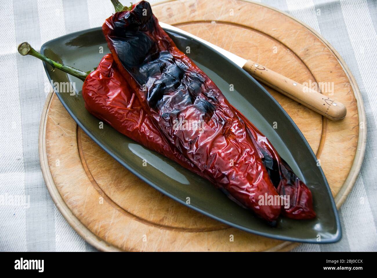 Lange rote Paprika auf dem Grill gegrillt zeigt Blasen Haut - Stockfoto