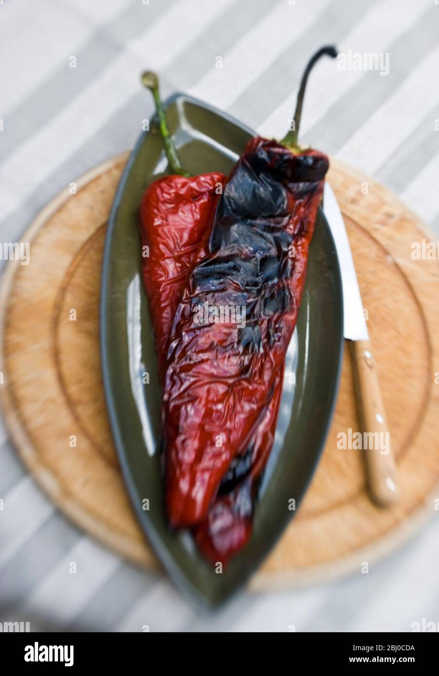 Lange rote Paprika auf dem Grill gegrillt zeigt Blasen Haut - Stockfoto