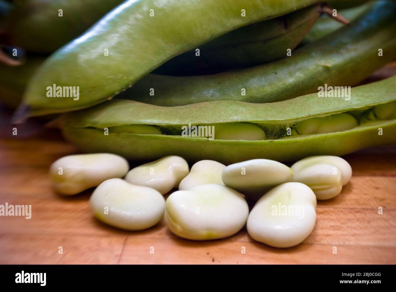 Frisch podded blassgrüne Bohnen auf Holzfläche - Stockfoto